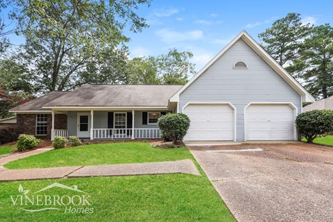 a white house with a lawn and a driveway